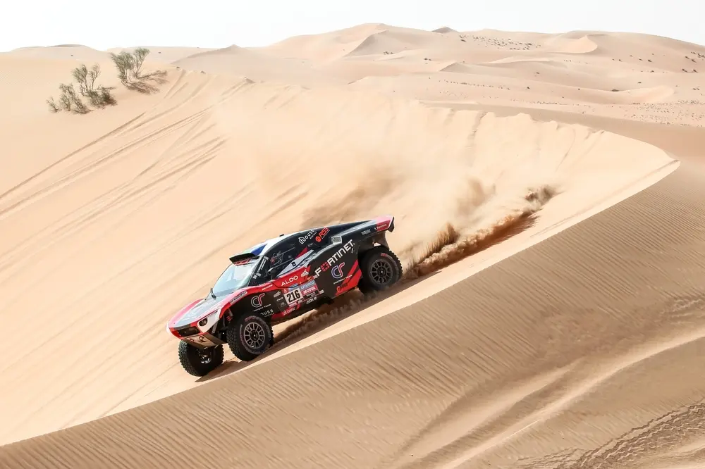 Dakar Rally car racing through desert dunes with event transportation for teams, crews, VIPs and personnel