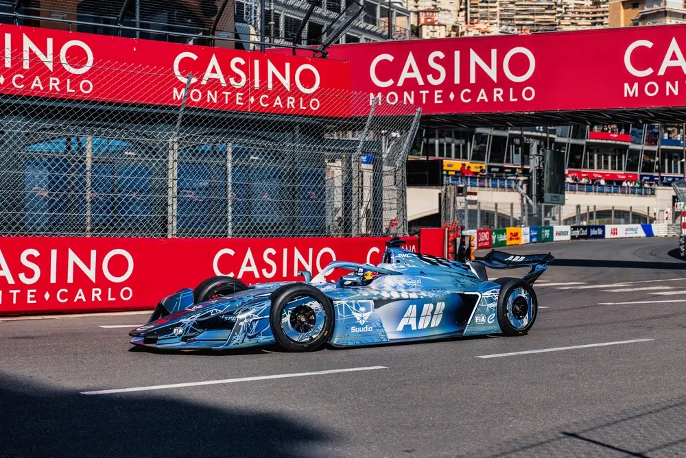 Formula E race car competing on the Monaco street circuit with event transportation for teams, VIPs and guests