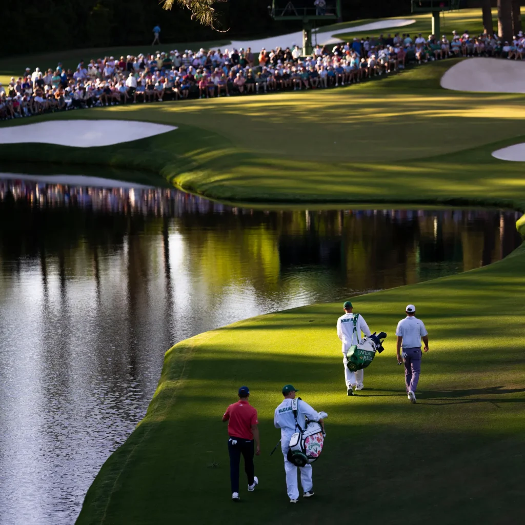 Players and caddies competing at the Masters golf tournament in Augusta